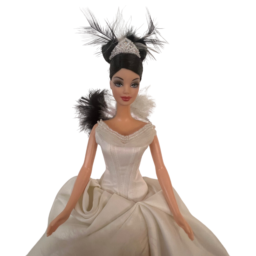 Barbie The Swan 2000 è una realizzazione Mattel del 2000 In questa versione possiamo vedere Barbie trasformarsi in un meraviglioso e leggiadro cigno nel suo abito da sera bianco con strascico e pence sulla coda, davanti più corto con dettagli di piume di cigno bianco e nero. Qualche difetto nel vestito.