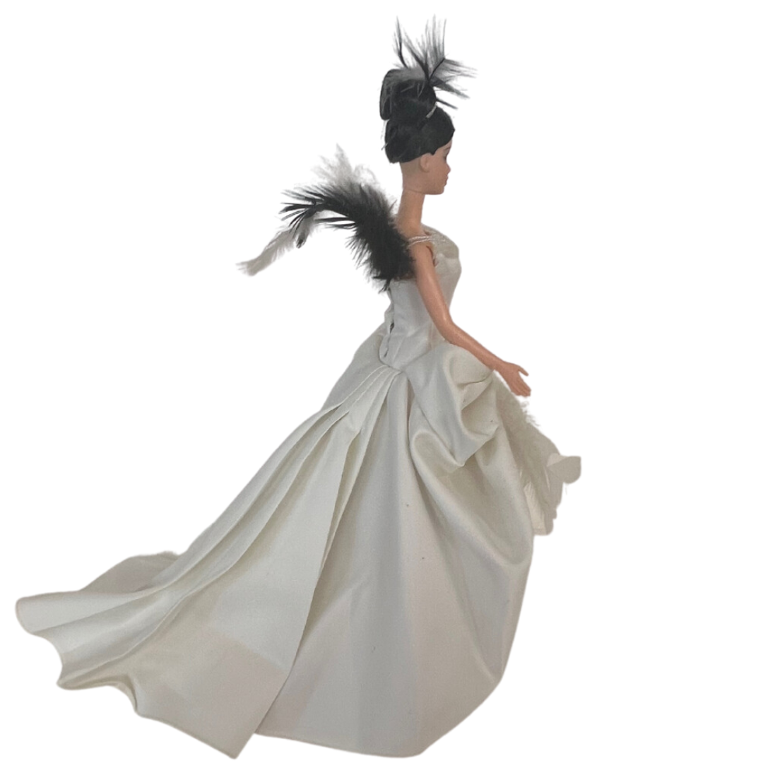 Barbie The Swan 2000 è una realizzazione Mattel del 2000 In questa versione possiamo vedere Barbie trasformarsi in un meraviglioso e leggiadro cigno nel suo abito da sera bianco con strascico e pence sulla coda, davanti più corto con dettagli di piume di cigno bianco e nero. Qualche difetto nel vestito.