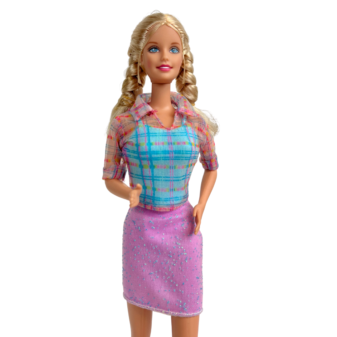 La bambola Barbie dai capelli biondi e occhi azzurri indossa una gonna viola scintillante, un top blu con strisce trasparenti sopra, un paio di scarpe viola e bianche. manca passeggino e bambola piccola