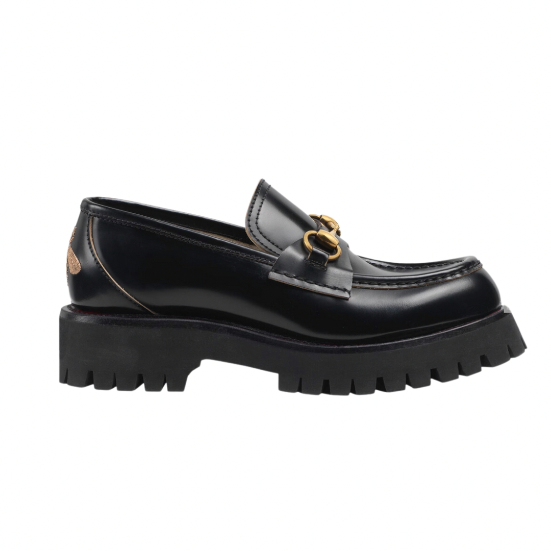 Mocassino Horsebit con suola a cararmato con fodera blu con stampa a boccioli di rosa sulla soletta. Un pilastro della storia di Gucci dagli anni '50, il classico mocassino Horsebit collega il passato al presente. Un omaggio al patrimonio della Casa radicato nel mondo equestre, la forma emblematica è rielaborata in una forma contemporanea su una suola di gomma.