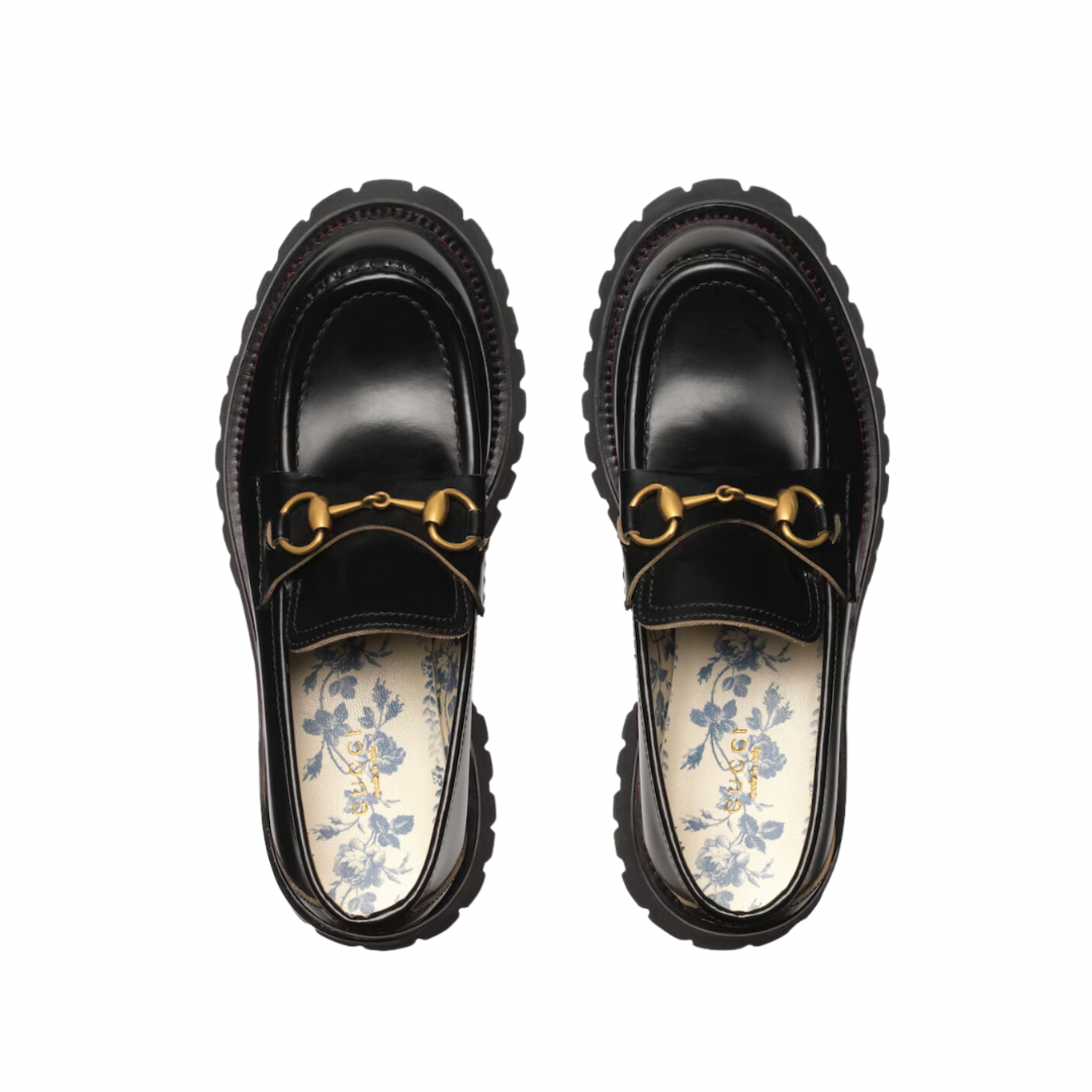 Mocassino Horsebit con suola a cararmato con fodera blu con stampa a boccioli di rosa sulla soletta. Un pilastro della storia di Gucci dagli anni '50, il classico mocassino Horsebit collega il passato al presente. Un omaggio al patrimonio della Casa radicato nel mondo equestre, la forma emblematica è rielaborata in una forma contemporanea su una suola di gomma.