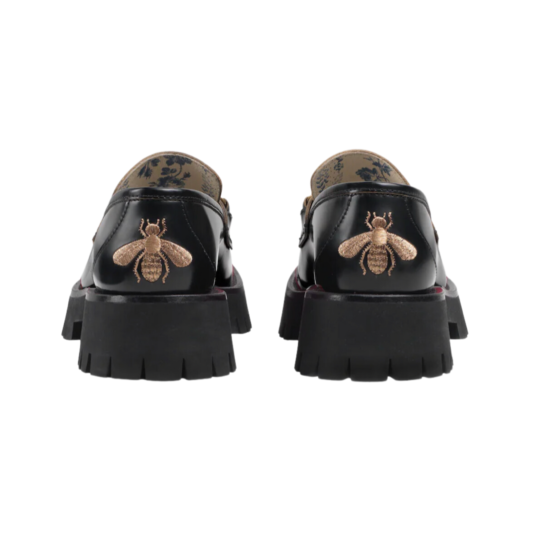 Mocassino Horsebit con suola a cararmato con fodera blu con stampa a boccioli di rosa sulla soletta. Un pilastro della storia di Gucci dagli anni '50, il classico mocassino Horsebit collega il passato al presente. Un omaggio al patrimonio della Casa radicato nel mondo equestre, la forma emblematica è rielaborata in una forma contemporanea su una suola di gomma.