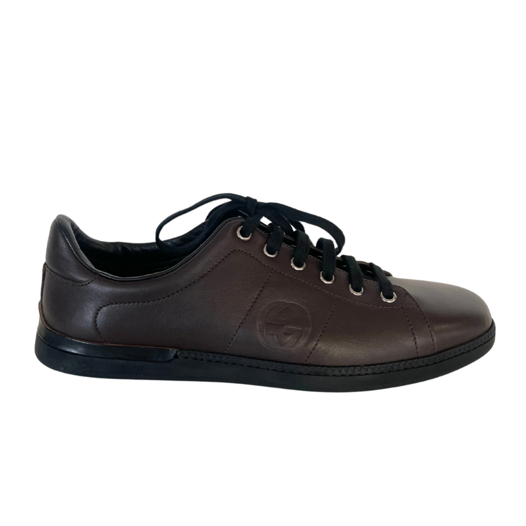 Scarpa sneakers in pelle liscia testa di moro con stringa e suola bassa nera con logo laterale.
