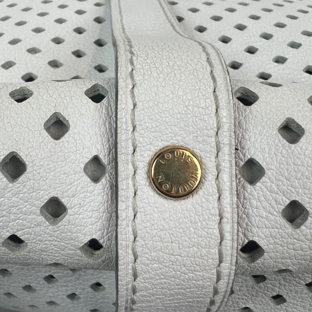 Immergiti nel lusso con la nostra Borsa 'Saumur’ di Louis Vuitton, in pelle traforata bianca, realizzata per la collezione Croisette del 2012. Questa borsa, pari al nuovo, presenta una doppia patella e una pratica tracolla regolabile per rendere la tua borsa pratica e leggerissima questa borsa è l'accessorio ideale per una donna dinamica ma che ci tiene ad essere fashion in maniera discreta.