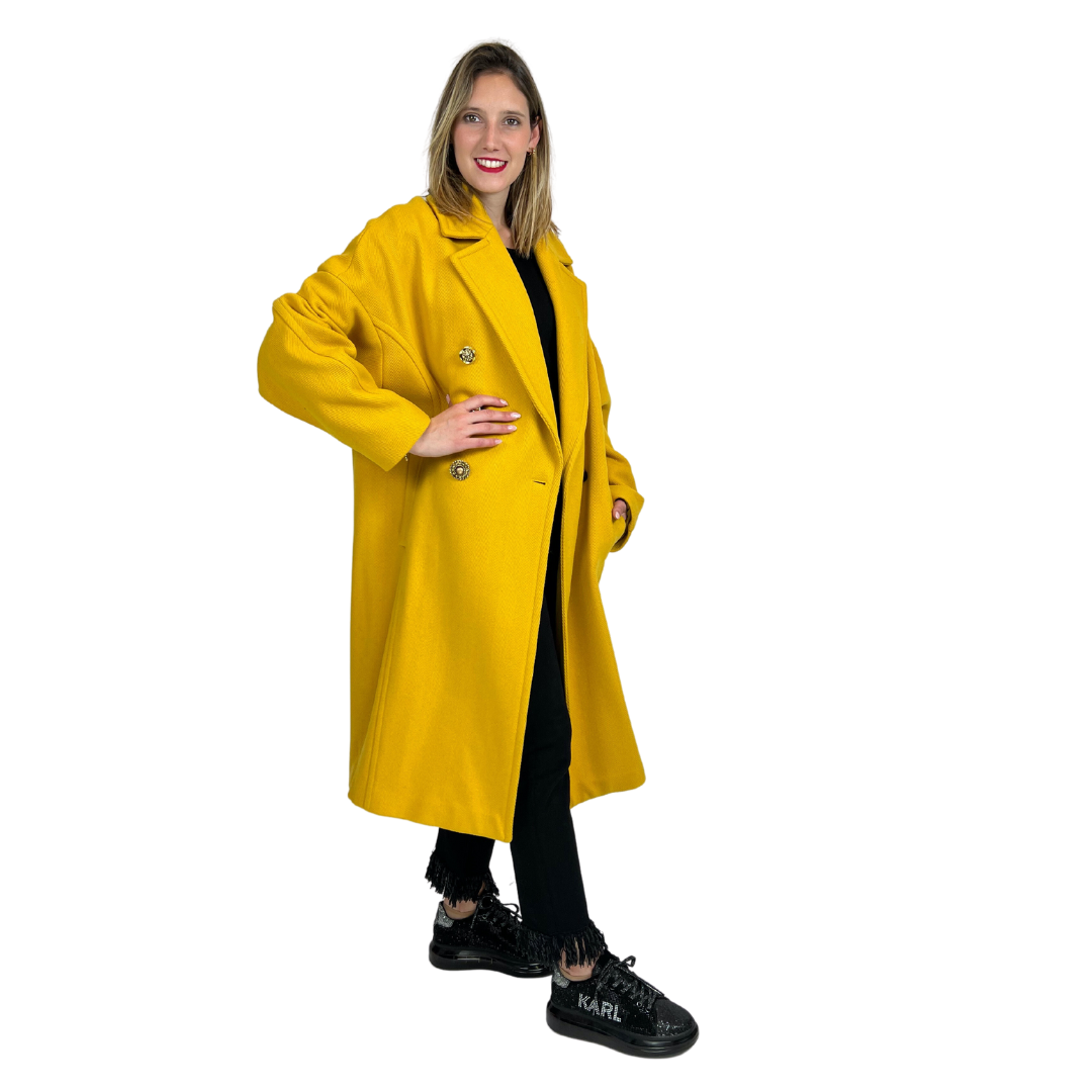 Cappotto lungo giallo ocra con tessuto fatto a costine, chiusura con bottoni gioiello diversi tra loro. Vestibilità Over.