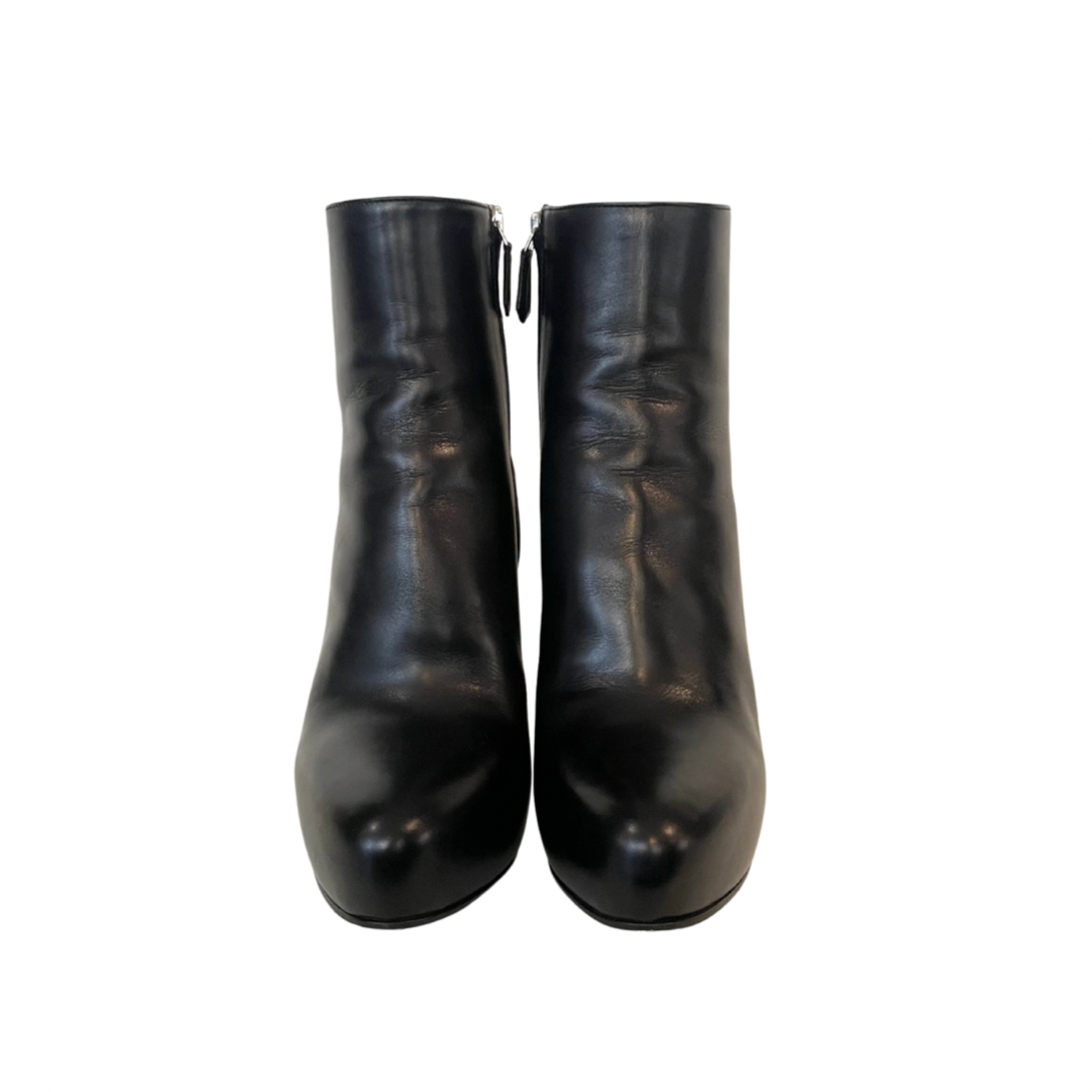 Scarpa stivaletto nero con gambale basso sopra alla caviglia in pelle liscia e leggermente a punta. Con logo oro sulla suola. Altezza del tacco: 11 cm con plateaux interno di 3 cm