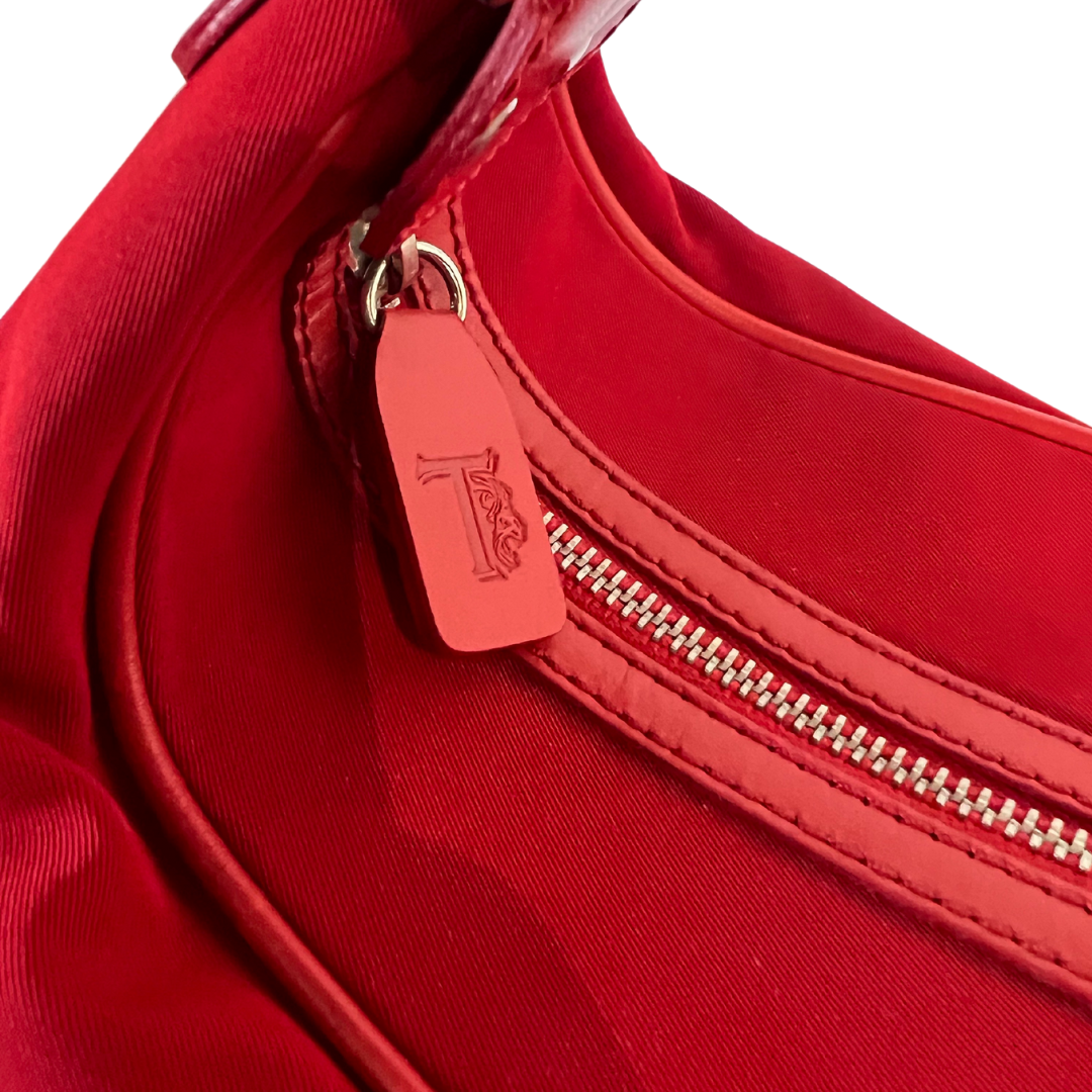 Borsa bauletto tessuto rosso con inserto in pelle rossa, tasche laterali esterne, gommini sul fondo.