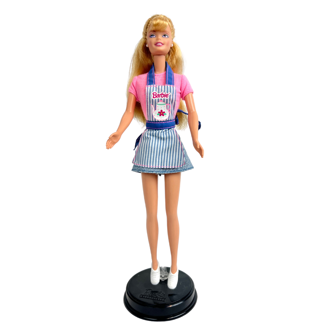 Barbie Dolce Snack è una produzione Mattel del 1998.  Questa versione di Barbie dai lunghi capelli biondi, indossa t-shirt rosa, una gonna corta in jeans e un grembiule da cucina rigato blu e bianco con rifiniture rosa, una cintura e bretelle in jeans, delle scarpe bianche.