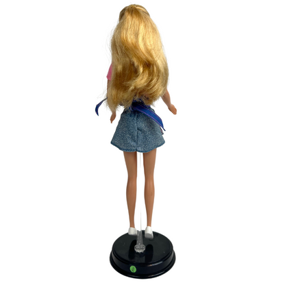 Barbie Dolce Snack è una produzione Mattel del 1998.  Questa versione di Barbie dai lunghi capelli biondi, indossa t-shirt rosa, una gonna corta in jeans e un grembiule da cucina rigato blu e bianco con rifiniture rosa, una cintura e bretelle in jeans, delle scarpe bianche.