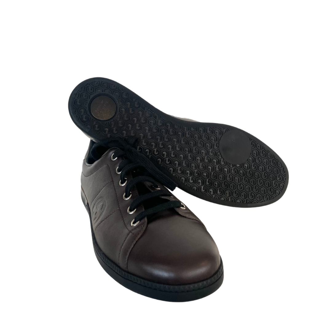 Scarpa sneakers in pelle liscia testa di moro con stringa e suola bassa nera con logo laterale.