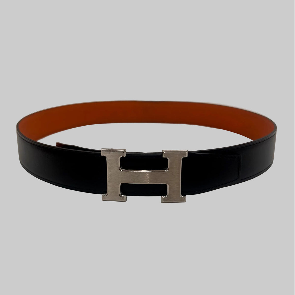 HERMES Cintura "Iconic Classic" reversibile nera e arancione con fibbia H argento