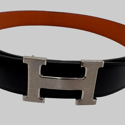 HERMES Cintura "Iconic Classic" reversibile nera e arancione con fibbia H argento