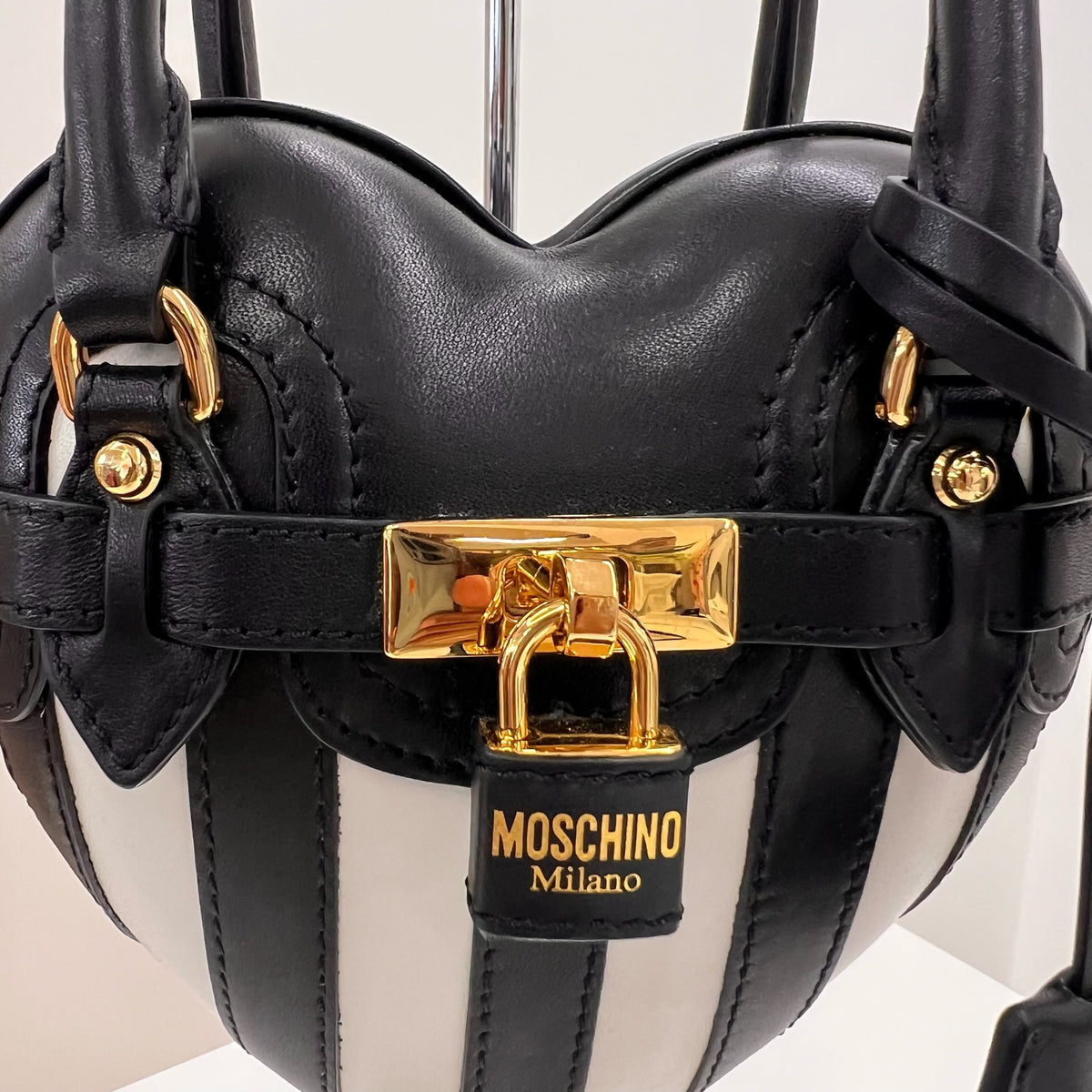 MOSCHINO COUTURE Borsa "Padlock Heart" a forma di cuore in pelle nera con righe bianche