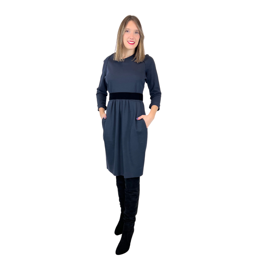 Abito in tessuto di maglia elasticizzata blu scuro con taglio in vita, gonna con pence, tasche e cintura elastica nera in velluto, girocollo.  Tg. L