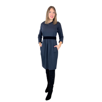 Abito in tessuto di maglia elasticizzata blu scuro con taglio in vita, gonna con pence, tasche e cintura elastica nera in velluto, girocollo.  Tg. L