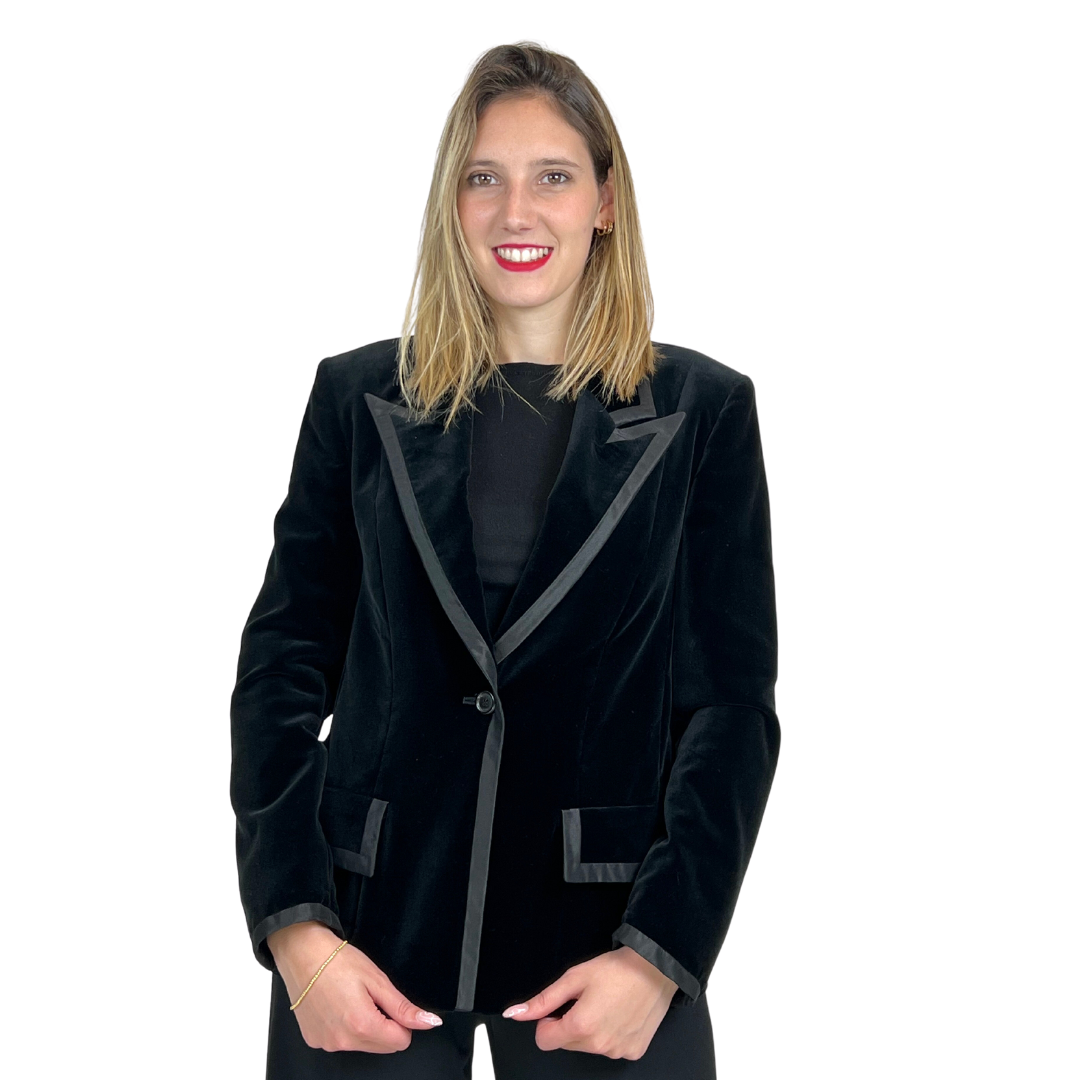 Giacca blazer in velluto rasato nero con una bordatura in raso.  La chiusura è ad un bottone, dotata di due patelle applicate.