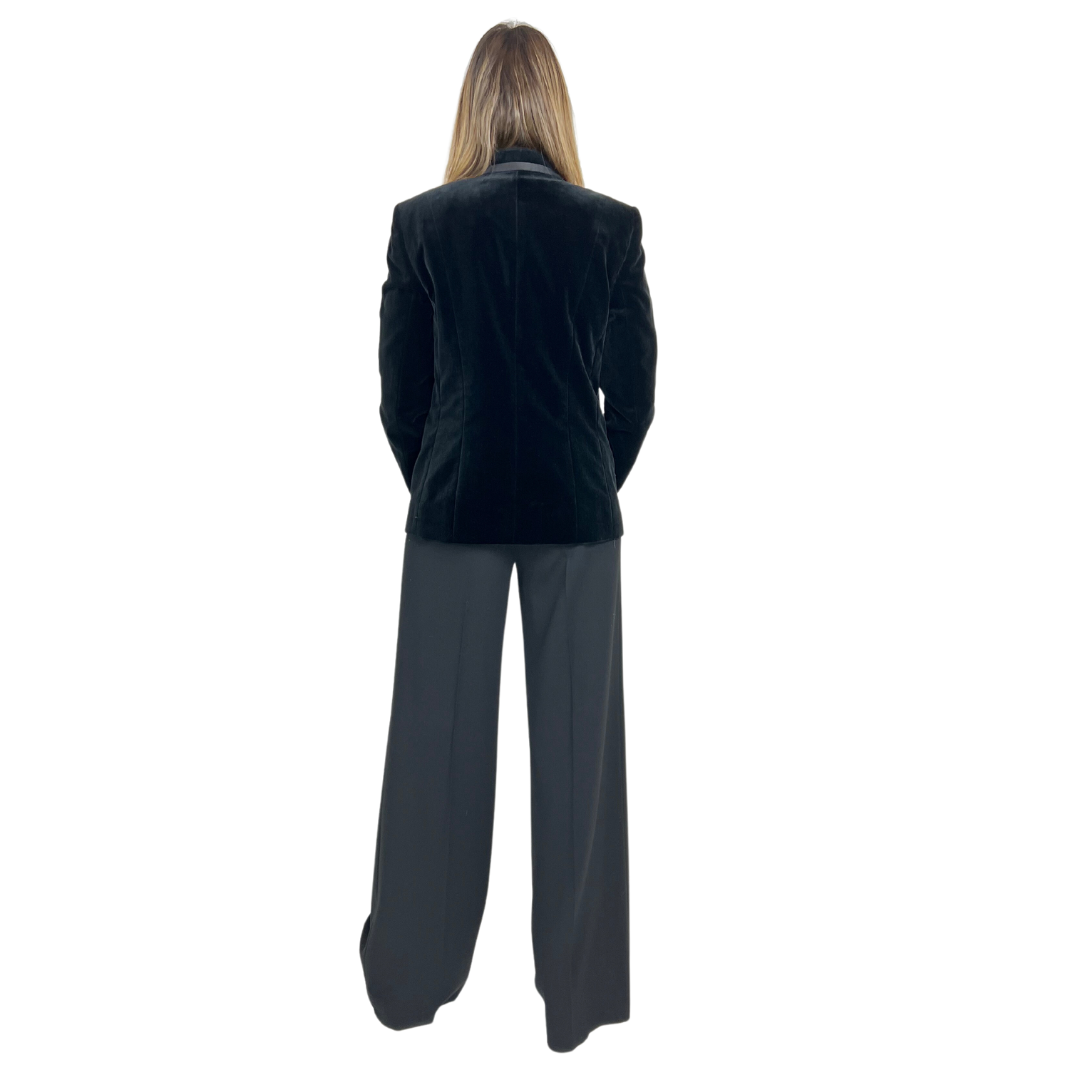 Giacca blazer in velluto rasato nero con una bordatura in raso.  La chiusura è ad un bottone, dotata di due patelle applicate.