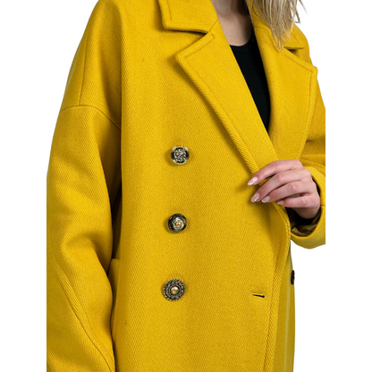 Cappotto lungo giallo ocra con tessuto fatto a costine, chiusura con bottoni gioiello diversi tra loro.  Vestibilità Over.