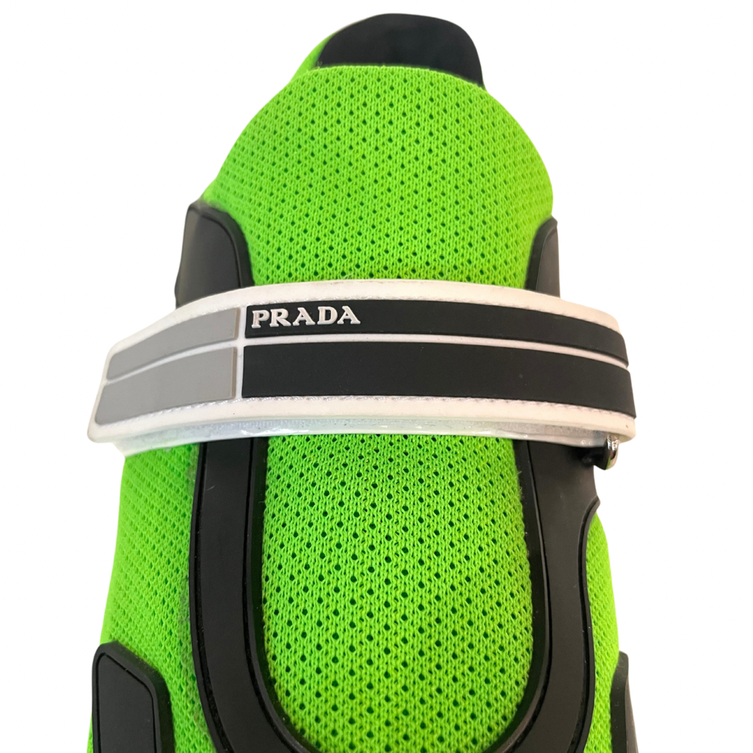 Scarpa sneakers in tessuto verde acido con chiusura a strappo, con scritta Prada sulla suola verde e nera.
